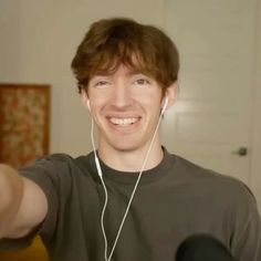 a young man wearing headphones is smiling