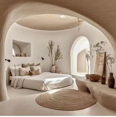 a bedroom with white walls and an arched doorway that leads to a bed in the middle