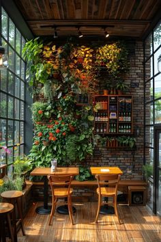 an indoor dining area with plants growing on the wall and wooden tables in front of them