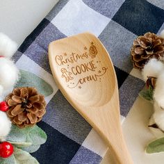 a wooden spoon sitting on top of a table next to cotton balls and pine cones