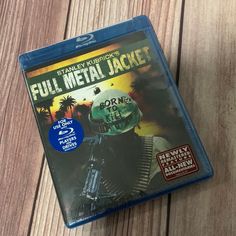 the blu cover for full metal jacket is laying on a wooden table with it's reflection