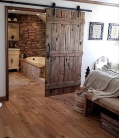 an open door leading to a bedroom with a bed and bathtub in the background