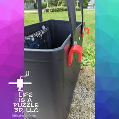 a black and red trash can sitting on top of a grass covered field