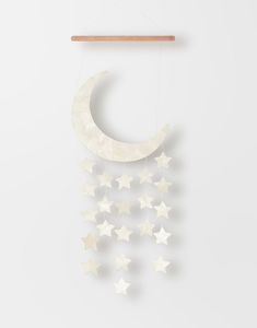 the moon and stars mobile is hanging in front of a white wall with a wooden hanger