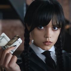 a woman with long black hair holding money in her hand