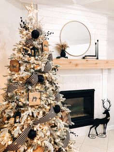 a decorated christmas tree in front of a fireplace with black and white decorations on it