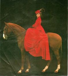 a woman in a red dress is riding a horse