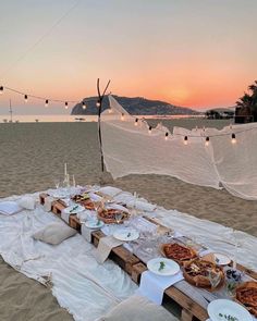 a table set up on the beach with food