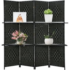 a room divider with four shelves and flowers