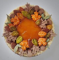 a cake decorated with leaves and caramel sauce