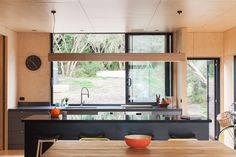 a kitchen with black counter tops and stools next to a bike parked in front of the window