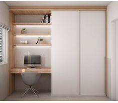 a computer desk sitting in front of a white sliding door next to a book shelf