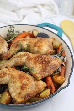 a pan filled with chicken and vegetables on top of a table