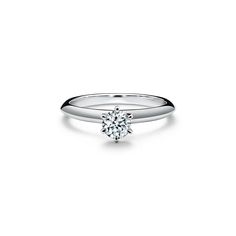 a white gold ring with a single diamond