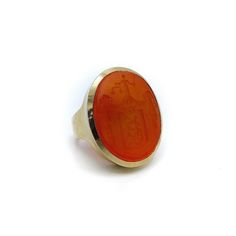 This is a spectacular carved carnelian 14 karat gold signet ring. It is part of Kirsten's Corner signature line. Starting with a beautifully carved carnelian intaglio, a simple but sophisticated 14 karat gold bezel set mount was designed. The carnelian Intaglio tablet measures 26mm x 22mm x 5mm and is bezel set. The ring has a sleek modern profile and works well as a unisex ring. The ring weighs 20.6 grams and is a size 7 1/2. It can be resized up of down a size or two.  The image on the intaglio is complex, composed of many parts. The amorial bearing pictures drapery held up by floral bouquets. In front of that is shield with a lamb holding a flag (the figure of a lamb carrying a cross and standing on a mount is the sign of Christ crucified); or Agnus Dei with the vexillum. Below the lamb Gold Carnelian Signet Ring With Polished Finish, Classic Carnelian Signet Ring With Polished Finish, Classic Carnelian Signet Ring For Formal Occasions, Classic Carnelian Signet Ring For Formal Events, Formal Carnelian Oval Signet Ring, Formal Carnelian Signet Ring With Polished Finish, Formal Oval Carnelian Signet Ring, Classic Carnelian Round Signet Ring, Elegant Gold Signet Ring With Carnelian