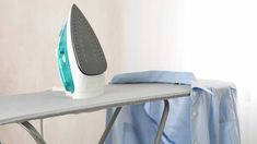 an iron is sitting on top of the ironing board