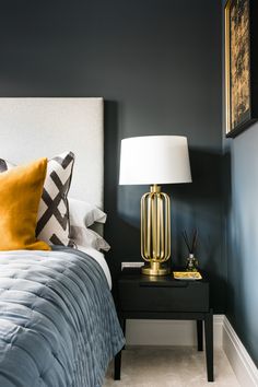 a bed room with a neatly made bed and a night stand next to the bed