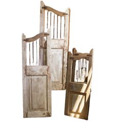 three old wooden doors are stacked on top of each other, with one open and the other closed