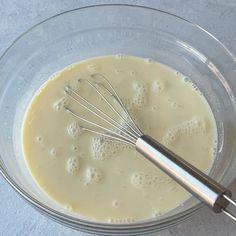 a whisk in a glass bowl filled with batter for making cake toppings