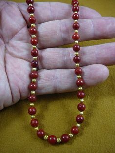 (Internal #V-30-7)  You are bidding on a beautiful, handmade, necklace made, round red bamboo coral 6 mm with gold plated spacer beads. Necklace is 16" long, with gold safety closure.* Want something larger, special order is $2.50 per inch.WE SHIP WORLDWIDE! Other accepted payment: Credit card (Mastercard/Visa/Discover) inquire for details. Spiritual Red Coral Round Bead Necklace, Red Coral Jewelry With Gold Beads, Gold Beaded Necklace With Polished Red Coral, Gold Necklace With Polished Red Coral Beads, Spiritual Red Beaded Necklaces With Gold Beads, Spiritual Red Beaded Necklace With Gold Beads, Red Coral Spacer Beads, Round Shape, Red Coral Spacer Beads, Red Coral Round Spacer Beads