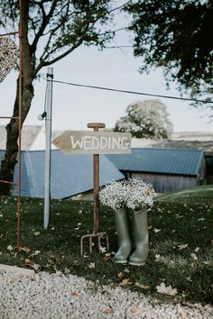 a couple of boots that are sitting in the grass next to a sign with wedding written on it