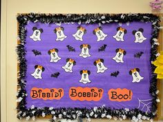 a bulletin board with mickey mouses and ghostes on purple background, surrounded by halloween decorations