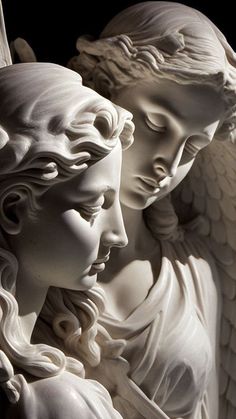 two white statues with angel wings on each one's head and the other behind them