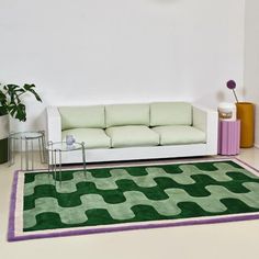 a white couch sitting on top of a green rug