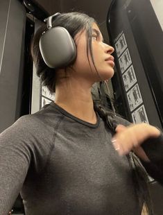 a woman wearing headphones standing in front of a mirror