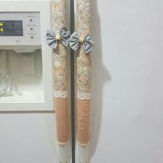 two toilet paper rolls with bows on them in front of a water dispenser