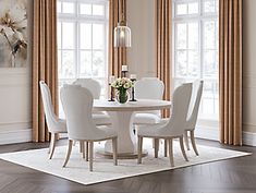 a dining room table with white chairs around it