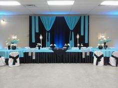 a banquet room set up with blue and black linens