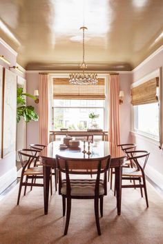 a dinning room table with chairs and a chandelier hanging from the ceiling