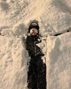 a young child is standing in the snow with his head stuck in some deep snow