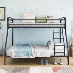 a black metal bunk bed sitting on top of a hard wood floor next to a blue wall