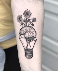 a black and white tattoo of a light bulb with flowers in it