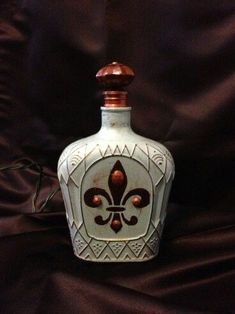 a white and brown fleur de liqueur bottle on a black cloth background