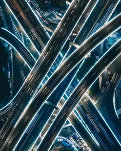 an aerial view of multiple roads and streets at night with long exposure lights on them