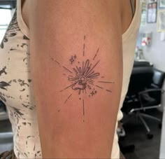 a woman's arm with a tattoo on it that has a star burst coming out of it