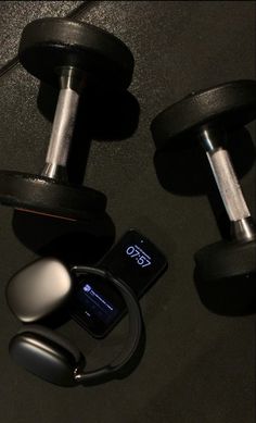 there are two dumbbells and an mp3 player next to each other