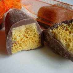 two pieces of chocolate on a plate next to an orange bow