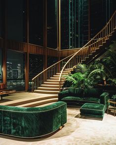 a living room filled with green couches next to a set of stairs and palm trees