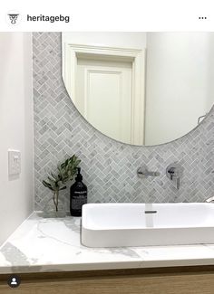 a white sink sitting under a mirror in a bathroom