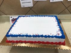 a sheet cake with red, white and blue frosting on it sitting on a table