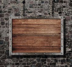 a wooden sign hanging from chains in front of a stone wall with a chain around it