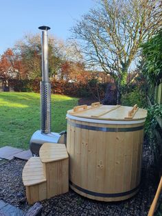 a wooden hot tub sitting in the middle of a garden