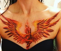 a woman wearing a black top with red and yellow wings on her chest