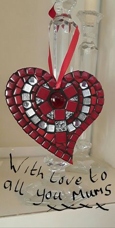 a red heart shaped ornament sitting on top of a table