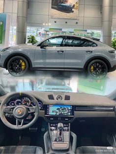 the inside of a car showroom with two different cars on display and one is grey