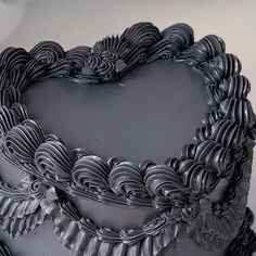 a heart shaped chocolate cake with icing and ruffles on the top, sitting on a table